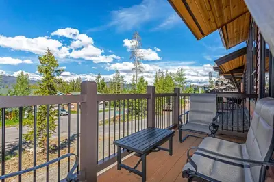 a balcony with a bench and a table and chairs at Treehouse Village 323 in Silverthorne