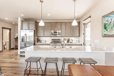a kitchen with a large island with four bar stools at Treehouse Village 323 in Silverthorne