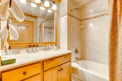 a bathroom with a sink and a tub and a mirror at Spacious 1Br Condo-River Run Village-Hot Tub & Kids Ski Free Condo in Keystone
