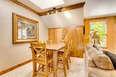 a dining room with a table and chairs and a couch at Spacious 1Br Condo-River Run Village-Hot Tub & Kids Ski Free Condo in Keystone