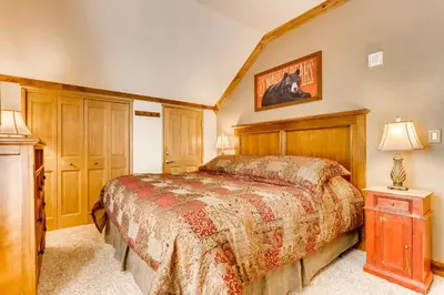 a bedroom with a bed and a table with a lamp at Spacious 1Br Condo-River Run Village-Hot Tub & Kids Ski Free Condo in Keystone