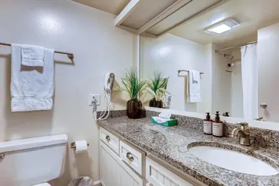 a bathroom with a sink and a toilet and a mirror at Spacious And Modern 2Br Premier- The Pines- Kids Ski Free Condo in Keystone