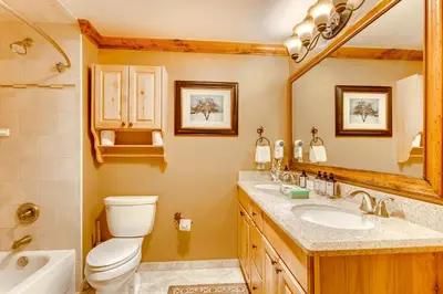 a bathroom with a toilet and a sink and a mirror at Heart Of River Run & Spacious 2Br Premier Condo in Keystone