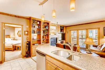 a kitchen with a sink and a living room with a bed at Heart Of River Run & Spacious 2Br Premier Condo in Keystone