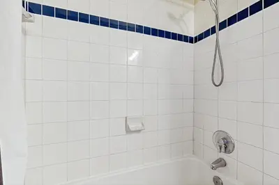 a white tiled bathroom with a shower and a tub at Bay Club 107 in Frisco