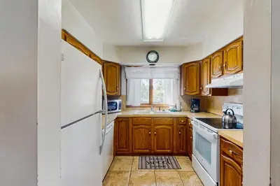 a kitchen with wooden cabinets and a white refrigerator at Deer Path Escape in Dillon