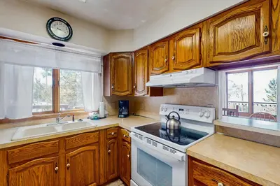 a kitchen with wooden cabinets and a stove top oven at Deer Path Escape in Dillon