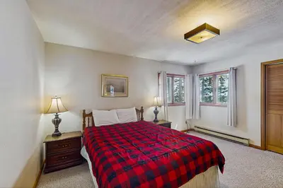 a bedroom with a bed with a red plaid blanket at Deer Path Escape in Dillon