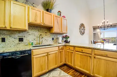 a kitchen with wooden cabinets and a black dishwasher at Forest Park 31E in Silverthorne