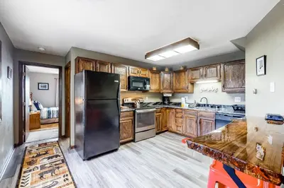 a kitchen with wooden cabinets and a stainless steel refrigerator at Buffalo Ridge Retreat in Silverthorne