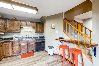 a kitchen with wooden cabinets and orange stools at Buffalo Ridge Retreat in Silverthorne