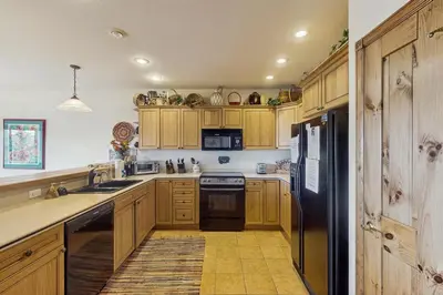 a kitchen with wooden cabinets and a black refrigerator at Lookout Ridge 63 in Dillon
