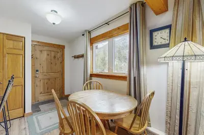 a dining room with a table and chairs and a clock at Ore House 8 in Frisco