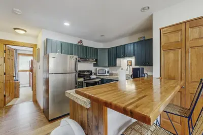 a kitchen with a wooden table and a refrigerator at Ore House 8 in Frisco