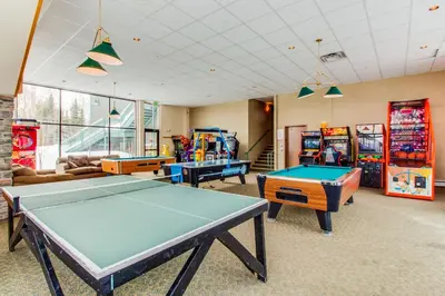 a room with a pool table and arcade games at Treehouse 206F in Silverthorne