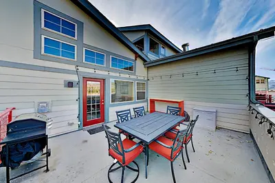 a patio with a table and chairs in front of a house at La Riva Del Lago 209 in Dillon