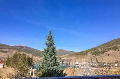 a christmas tree in front of a mountain at La Riva Del Lago 209 in Dillon