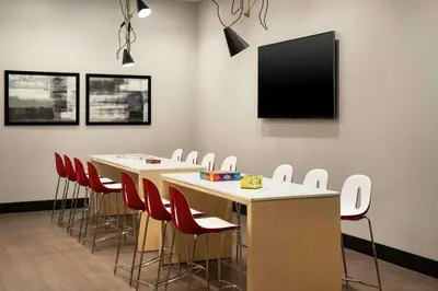 a conference room with tables and chairs and a flat screen tv at Tru By Hilton Denver Downtown Convention Center in Denver