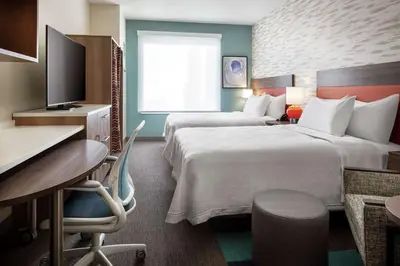 a hotel room with two beds and a desk at Home2 Suites By Hilton Denver Downtown Convention Center in Denver