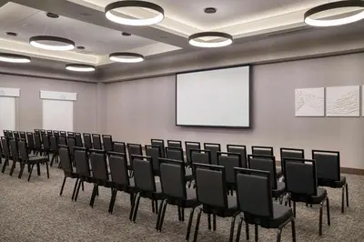 a conference room with chairs and a screen at Home2 Suites By Hilton Denver Downtown Convention Center in Denver