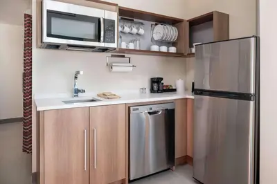 a kitchen with a stainless steel refrigerator and a microwave at Home2 Suites By Hilton Denver Downtown Convention Center in Denver