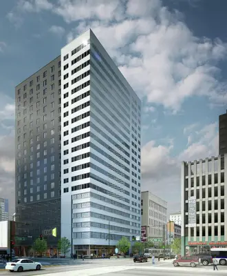 a tall glass building with cars in a city at Home2 Suites By Hilton Denver Downtown Convention Center in Denver