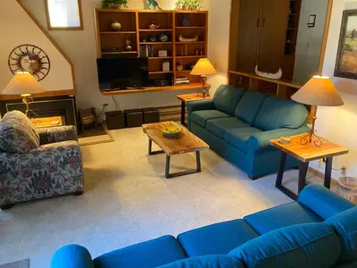 a living room with blue couches and a table at Tennis Townhomes 1326 by SummitCove Lodging in Keystone
