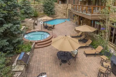 an overhead view of a pool with umbrellas and chairs at Premier 4 Bedroom Ski In, Ski Out Vacation Rental At The Timbers With The Best Access To Skiing In Keystone in Keystone