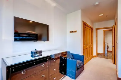a room with a dresser and a tv on the wall at Premier 4 Bedroom Ski In, Ski Out Vacation Rental At The Timbers With The Best Access To Skiing In Keystone in Keystone