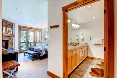 a bathroom with a sink and a bedroom at Premier 4 Bedroom Ski In, Ski Out Vacation Rental At The Timbers With The Best Access To Skiing In Keystone in Keystone