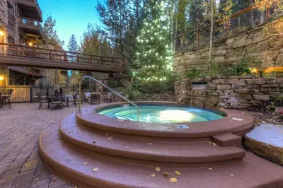 a hot tub in the middle of a patio at Premier 4 Bedroom Ski In, Ski Out Vacation Rental At The Timbers With The Best Access To Skiing In Keystone in Keystone