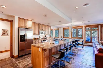 a kitchen with a large island with bar stools at Premier 4 Bedroom Ski In, Ski Out Vacation Rental At The Timbers With The Best Access To Skiing In Keystone in Keystone