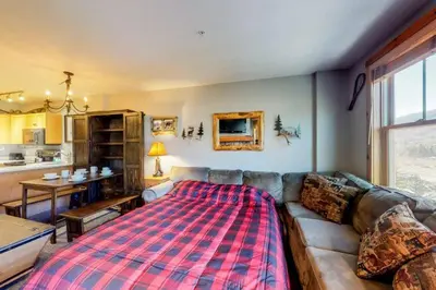 a living room with a couch with a blanket on it at 1 Bedroom Premier Mountain Condo In River Run Village Just A Short Walk To Shopping, Dining, And Skiing in Keystone