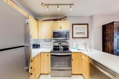 a kitchen with a stove and a sink and a refrigerator at 1 Bedroom Premier Mountain Condo In River Run Village Just A Short Walk To Shopping, Dining, And Skiing in Keystone