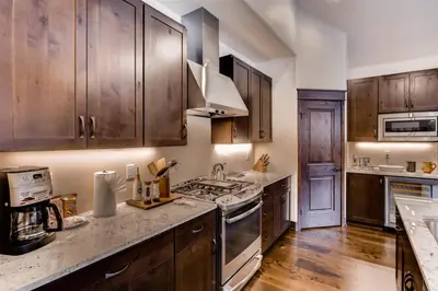 a kitchen with wooden cabinets and a stove top oven at Spacious 3 Bedroom Townhome In River Run Village Within Walking Distance To Gondola And Restaurants in Keystone
