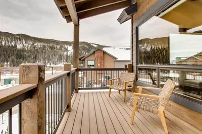 a balcony with two chairs and a view of the mountains at Spacious 3 Bedroom Townhome In River Run Village Within Walking Distance To Gondola And Restaurants in Keystone