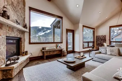 a living room with a large stone wall at Spacious 3 Bedroom Townhome In River Run Village Within Walking Distance To Gondola And Restaurants in Keystone