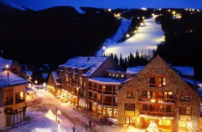 a ski lodge in a town with a ski slope at night at Luxury 1 Bedroom Mountain Condo In River Run Village With Expansive Mountain Views And Walking Distance To Ski Slopes in Keystone