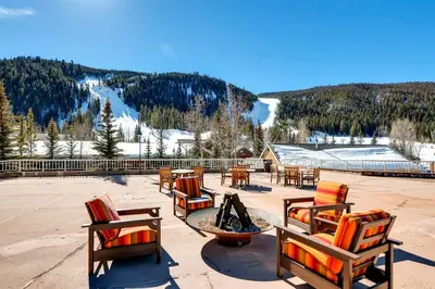 a patio with chairs and a table and a fire pit at Ski In 2 Bedroom At Chateaux Dumont Keystone in Keystone