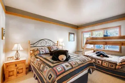a bedroom with a teddy bear laying on a bed at Ski In 3 Bedroom At Chateaux Dumont Keystone in Keystone