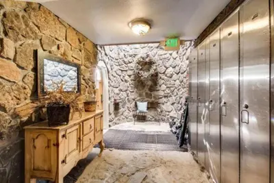 a stone bathroom with a walk in shower and a stone wall at Ski In 3 Bedroom At Chateaux Dumont Keystone in Keystone
