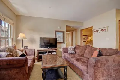 a living room with two couches and a flat screen tv at 3 Bedroom Mountain Condo In River Run Village With Expansive Mountain Views And Walking Distance To Ski Slopes in Keystone