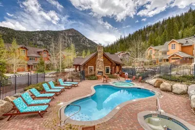 a swimming pool with lounge chairs and a house at Private Family Friendly 2 Bedroom Townhome Located In East Keystone With Access To Free Shuttle Service in Keystone