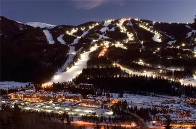 a snowy mountain with lights on a ski slope at night at Private Family Friendly 2 Bedroom Townhome Located In East Keystone With Access To Free Shuttle Service in Keystone