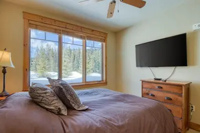 a bedroom with a large bed and a flat screen tv at Private Family Friendly 2 Bedroom Townhome Located In East Keystone With Access To Free Shuttle Service in Keystone