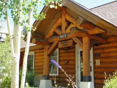 a log cabin with a sign in front of it at Private 2 Bedroom Townhome Located In East Keystone With Access To A Firepit, Hot Tub, And Billiards in Keystone