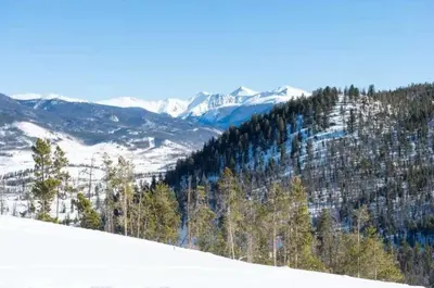 a snow covered hill with trees and mountains at Private 2 Bedroom Townhome Located In East Keystone With Access To A Firepit, Hot Tub, And Billiards in Keystone