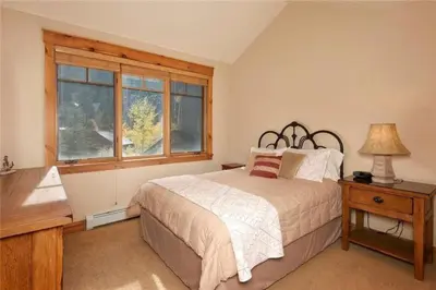 a bedroom with a bed and a window at Private 2 Bedroom Townhome Located In East Keystone With Access To A Firepit, Hot Tub, And Billiards in Keystone