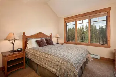 a bedroom with a bed and a large window at Private 3 Bedroom Townhome Located In East Keystone With Access To A Firepit, Hot Tub, And Billiards in Keystone