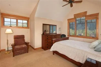 a bedroom with a bed and a dresser and a chair at Private 3 Bedroom Townhome Located In East Keystone With Access To A Firepit, Hot Tub, And Billiards in Keystone